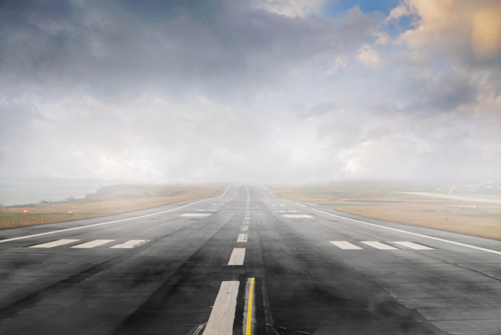 Business Aviation Group An empty runway with a cloudy sky, offering Aviation Real Estate Services.